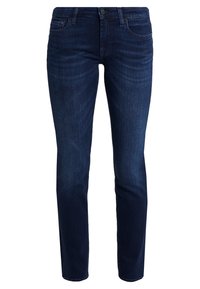Vaqueros de mezclilla azul oscuro con un corte slim, cinco bolsillos, un leve desgaste y costuras en contraste. Cierre clásico con botón y cremallera en la cintura.