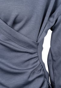 Grijze lange mouwen top met een ruches ontwerp aan de zijkant, gemaakt van zachte, textuurstof. Naaddetail verbeterd de silhouet.