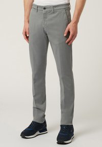Grå chinos i bomull med slim fit, med knappstängning, framfickor och en mjuk yta. Kombinerat med mörka sneakers.