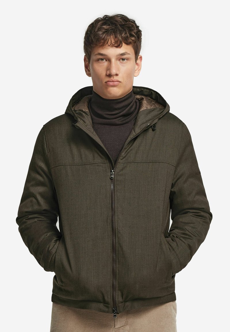 Mørkegrøn isoleret jakke med hætte, med lynlås på fronten, to sidelommer og en glat tekstur. Foring i en lysere nuance.