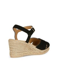 Sandalo wedge in suede nero con cinturino alla caviglia regolabile, punta aperta e suola in juta intrecciata con texture a coste.