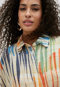 Multicolored, lightweight button-up shirt with a grid pattern and golden textured accents, featuring vertical stripes in blue, orange, and green.