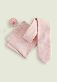 Cravate rose à motif paisley avec pochette assortie et épingle en tissu en forme de fleur, présentant des motifs blancs complexes et une texture lisse.