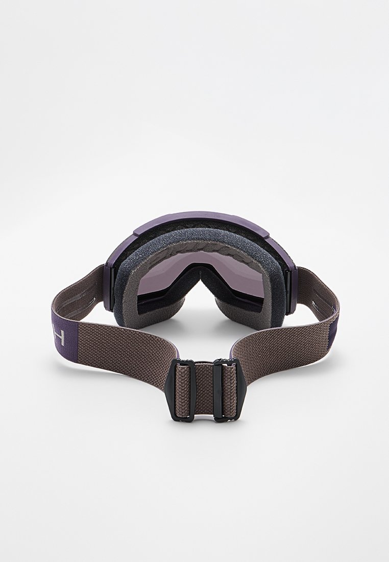 Skibrille mit lila getönten Gläsern, dickem Schaumstoffpolster und einem verstellbaren braunen Riemen mit schwarzem Kunststoffverschluss.