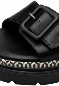 Sandalo in pelle nera con una fascia larga, fibbia rettangolare e una piattaforma nera con texture, caratterizzata da una banda di accento bianca a motivo.