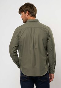 Camicia da uomo verde oliva a maniche lunghe con colletto a punte, cucitura sul retro e maniche con polsini, realizzata in un tessuto liscio.