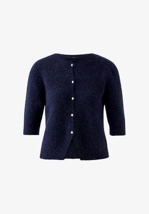 Cardigan court bleu marine à manches courtes en tissu duveteux, avec cinq petits boutons blancs sur le devant et un col rond.