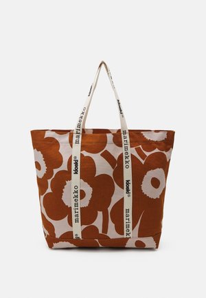 Grand sac fourre-tout en tissu avec motif floral marron et blanc, anses blanches imprimées des logos "marimekko" et "kioski".