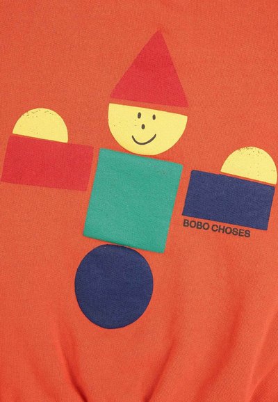 Camisa naranja con formas geométricas coloridas: cuadrado rojo, cuadrado verde, círculo amarillo con cara, círculo azul y el texto impreso "BOBO CHOSES."