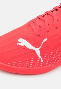 Puma löparskor i skarpt röd färg med texturerad yta, vit logotyp och dekorativa spår. Har snörningsdesign och gummisulor.