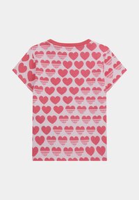 Tricou cu mânecă scurtă din bumbac roz deschis, având un model repetat de inimioare roz închis, cu text de brand intercalat.