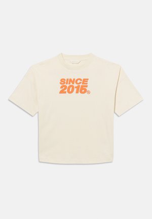 Off-white T-shirt met korte mouwen en oranje, gedurfde tekst "SINCE 2015" gecentreerd op de borst, ronde hals, ontspannen pasvorm.