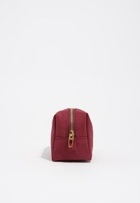 Neceser de tela rojo de forma rectangular, con cremallera dorada y material texturizado. Construcción resistente con elementos de diseño minimalista.
