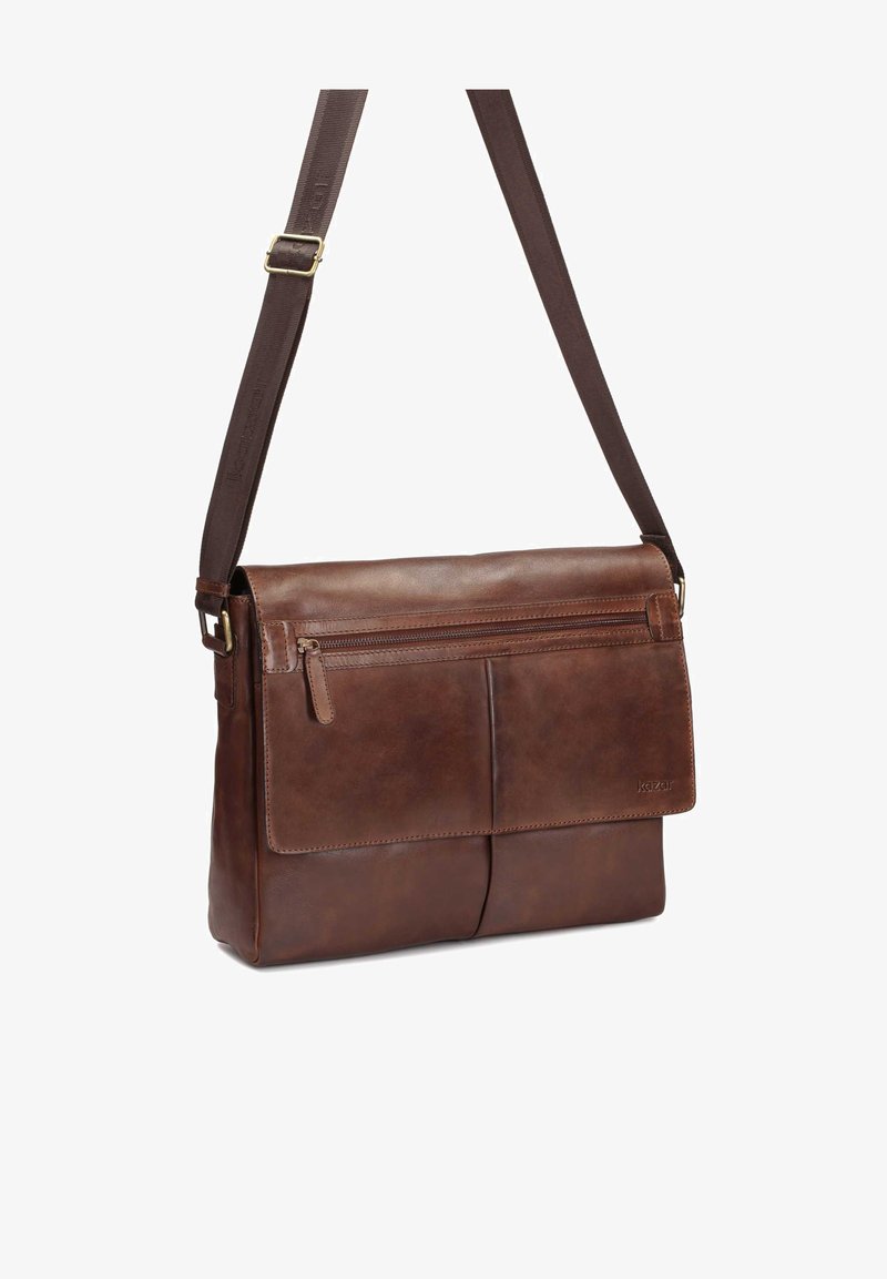 Borsa a tracolla in pelle marrone con tracolla regolabile, tasca frontale con zip e copertura a patta con due scomparti frontali. Texture liscia.