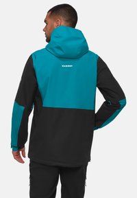 Schwarze und türkise Outdoor-Jacke mit Kapuze, seitlichen Reißverschlusstaschen und einem Logo auf dem oberen Rücken. Das Material scheint wetterfest und strukturiert zu sein.