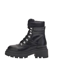 Botines negros de cuero con un cuello acolchado, que presentan ojetes plateados, cordones gruesos y una suela gruesa de goma.