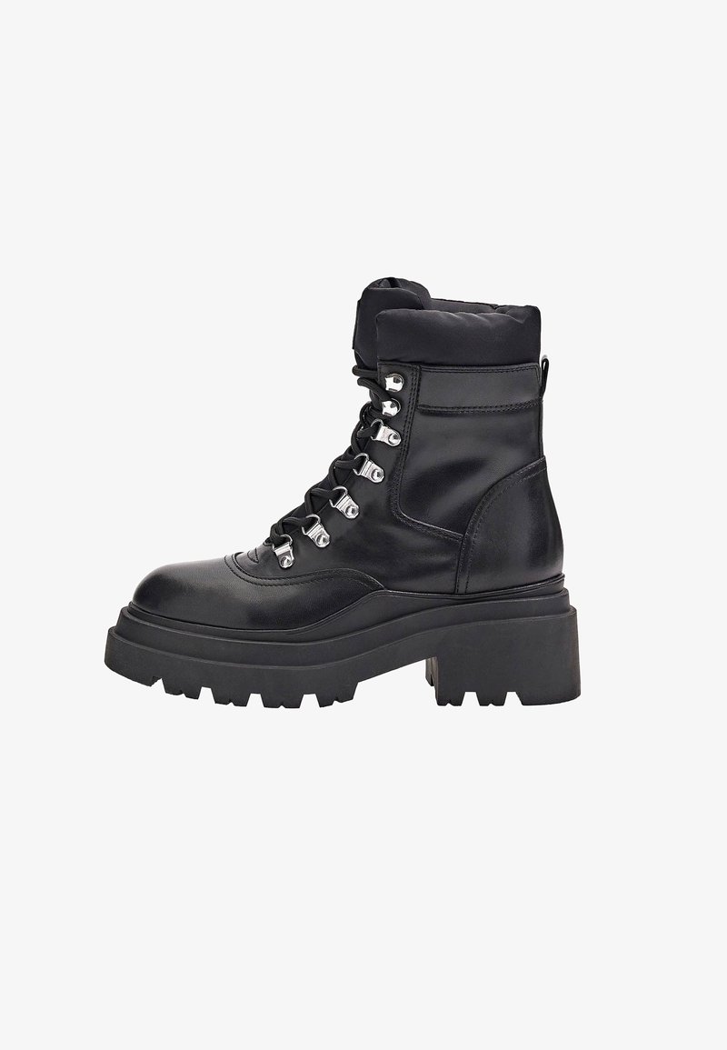 Botines negros de cuero con un cuello acolchado, que presentan ojetes plateados, cordones gruesos y una suela gruesa de goma.