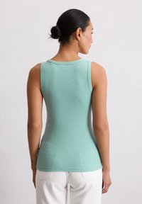 Débardeur côtelé vert menthe avec un col rond et une conception sans manches, silhouette ajustée et texture lisse.