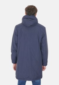 Parka con cappuccio blu navy, dal profilo lungo e affusolato, con una finitura liscia e opaca. Presenta un design di lunghezza media e cuciture minime.