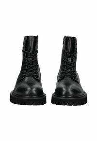 Stivali alla caviglia in pelle nera con finitura testurizzata, laccio anteriore, punta rinforzata e suola in gomma spessa. Dettaglio con zip sul retro.