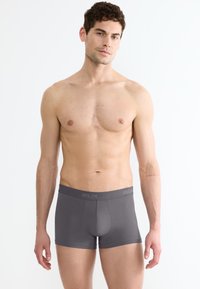 Boxer in cotone grigio con un morbido elastico in vita, design aderente e texture liscia. L'elastico presenta dettagli di branding ricamati.