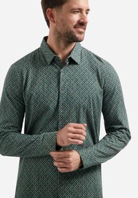 Groene geprinte longsleeve-shirt met een geometrisch patroon, knoopsluiting en knopen aan de voorkant. Gemaakt van katoenmix.