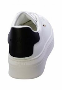Sneaker bianco con un accentuazione nera sul tallone, tomaia in pelle liscia, pannello testurizzato e suola spessa bianca. Design minimalista con branding sottile.