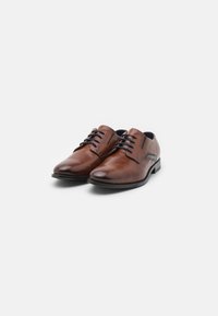 Bruine leren dresschoenen met een gladde textuur, ronde neus en een vetersluiting met zes gaatjes. Inclusief zij-accentdetails.