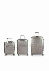 Tre valigie rigide in un finish grigio metallizzato, con un motivo a diamante, maniglie retrattili e ruote scorrevoli.