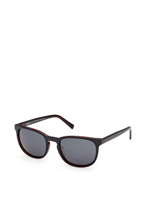 Prostokątne ciemne okulary przeciwsłoneczne w kolorze żółwia z czarnymi przyciemnianymi soczewkami i cienkimi zausznikami, przedstawione pod kątem na białym tle.