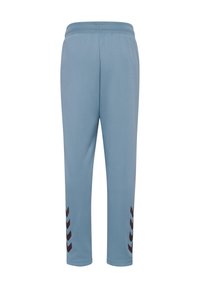 Jasnoniebieskie spodnie sportowe z elastycznym paskiem w talii i czarnymi akcentami w kształcie chevronu przy mankietach, wykonane z gładkiego, oddychającego materiału.