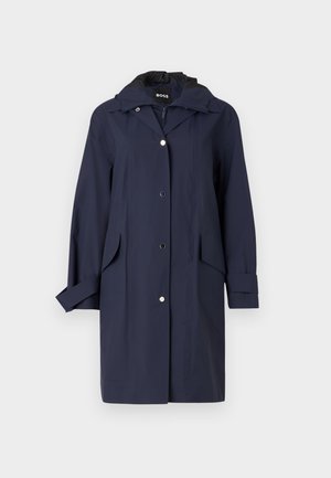 Imperméable bleu marine avec capuche, fermeture à boutons, poches latérales et texture lisse. Présente un design élégant et décontracté avec des poignets réglables.