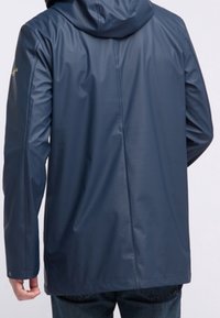 Navy waterproof jacket with a hood, smooth, glossy texture, long sleeves, and a straight cut. Features a back seam for added shape.