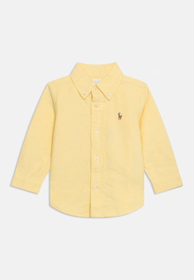Camisa amarilla de manga larga para niño pequeño, con botones, cuello y pequeño logo bordado de un caballo y jinete en el pecho.