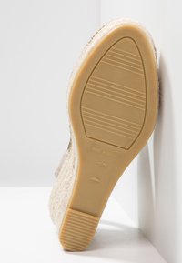 Espadrilky s béžovým textilním svrškem a tkanou jutu střední podešví. Gumová podešev s horizontálními drážkami, označena velikostí 37.