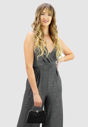 Gray shimmery jumpsuit with a deep V-neck and gathered waist, paired with a small black beaded handbag featuring a silver clasp and chain handle.