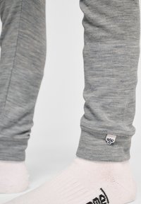 Szare, dopasowane legginsy wykonane z miękkiego, teksturowanego materiału. Posiadają małą metkę z logo blisko kostki oraz gładkie wykończenie. 