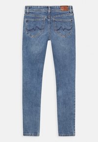 Jeans skinny de denim azul con una textura suave, tiro medio, bolsillos traseros con un patrón de costura ondulada y una etiqueta de cuero en la cintura.