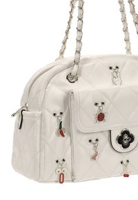 Bolso blanco acolchado con correas de cadena plateadas, bolsillo frontal, y adornos decorativos que incluyen una mariquita, un plátano y símbolos de la paz.
