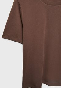 T-shirt en coton marron à manches courtes et col rond. Offre une texture lisse et présente des coutures simples et sans coutures apparentes.