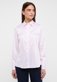Camicia a maniche lunghe rosa chiaro con colletto classico, tessuto morbido, leggero lucido e chiusura con bottoni sul davanti.