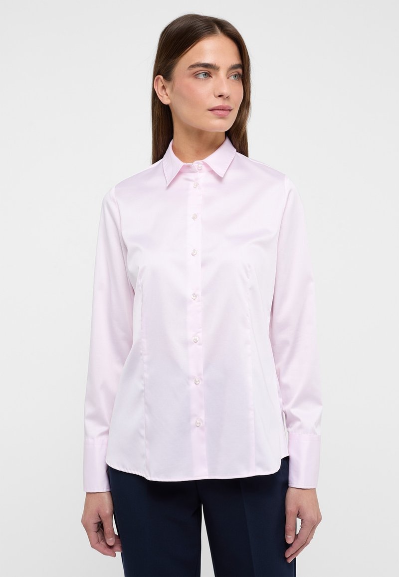Camicia a maniche lunghe rosa chiaro con colletto classico, tessuto morbido, leggero lucido e chiusura con bottoni sul davanti.
