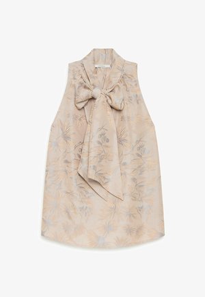 Blouse beige sans manches avec un motif floral subtil et un grand nœud noué au niveau du col, fabriquée en tissu brillant.