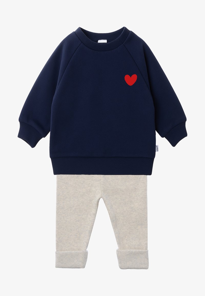 Marineblaue Sweatshirt mit rotem Herzakzent, kombiniert mit hellgrauen Strickhosen mit Bündchen. Weiches, lässiges Zweiteiler-Outfit.