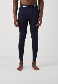 Marine Navy Techfit compressie legging met een nauwsluitende pasvorm, gladde textuur en witte gebrandmerkte tailleband. Eenvoudig ontwerp zonder extra patronen.