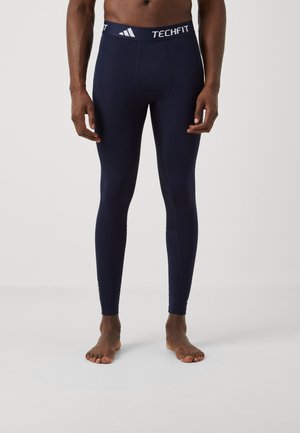 Marineblå Techfit kompressionsleggings med en tætsiddende pasform, glat tekstur og hvidt mærket liv. Enkel design uden yderligere mønstre.