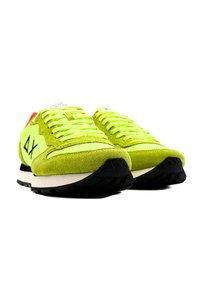 Sneaker verde lime con materiali in suede e mesh. Presentano lacci piatti, suole in gomma nera e una suola intermedia bianca a contrasto.