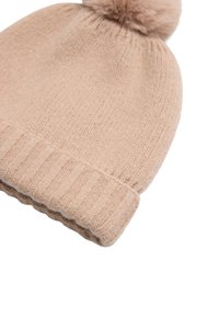 Gorro de punto en color beige claro con puño acanalado y pompón esponjoso en la parte superior, que presenta una textura suave y un diseño sencillo.