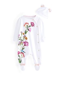 Tutina bianca con stampa floreale colorata, bottoni a pressione dorati e rifiniture rosate. Include un cappellino abbinato con orecchie e fiocco.