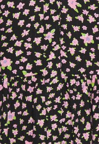 Tecido preto com um padrão floral apresentando flores cor-de-rosa e folhas verdes. A textura parece suave, com um brilho sutil.